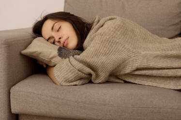 Junge Frau schläft auf Sofa zu Hause - EYF08004