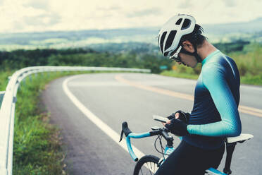 Mid Adult Man Using Phone Sitting On Bicycle At Road - EYF08024