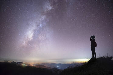 Seitenansicht der Silhouette Mid Adult Frau stehend gegen Star Feld in der Nacht - EYF08054