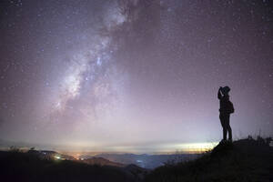 Seitenansicht der Silhouette Mid Adult Frau stehend gegen Star Feld in der Nacht - EYF08054