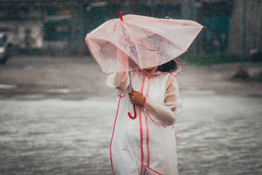 Woman With Umbrella Walking Against Sea - EYF08069