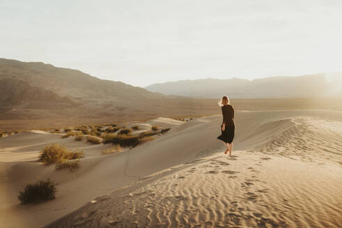 Rückansicht der Frau zu Fuß in der Wüste gegen den Himmel bei Sonnenuntergang - EYF08101