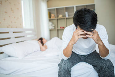 Tensed Man With Woman Sitting On Bed At Home - EYF08119