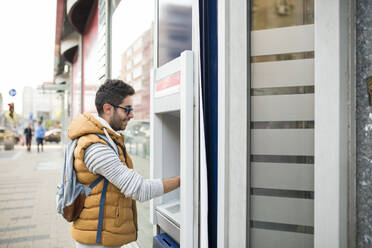 Seitenansicht des jungen Mannes mit Atm in der Stadt - EYF08122