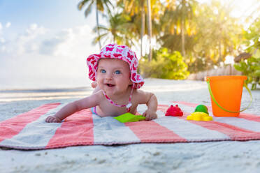 Smiling Cute Girl Looking Away While Lying On Towel At Beach - EYF08201