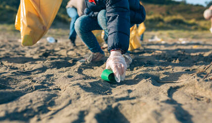 Low Section Of Girl Picking Garbage At Beach - EYF08220