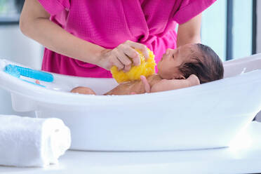 Midsection Of Mother Giving Bath To Son At Home - EYF08238