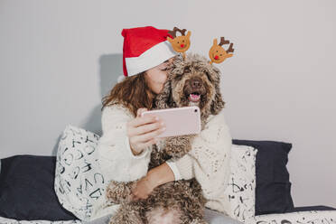 Woman With Dog Taking Selfie On Bed At Home - EYF08241