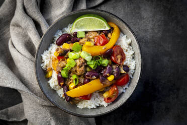 Bowl of Mexican rice with bell peppers, tofu, kidney beans, tomatoes, corn, lime and scallion - LVF08932