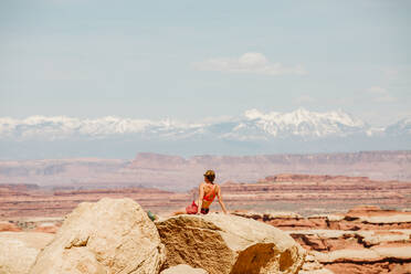 Wanderin im Sport-BH entspannt sich an einem Aussichtspunkt in The Maze Utah - CAVF85827