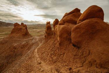 Path winds its way up bulbous red clay sandstone formations at dusk - CAVF85858