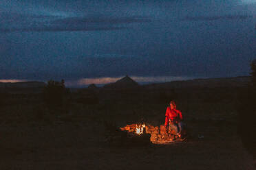 Frau neben einem Lagerfeuerring auf blm land in der Nähe von moab utah - CAVF85904