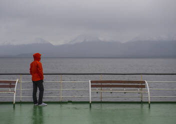 Woman looking at grim scenery from passenger vessel in Patagonia - CAVF86124