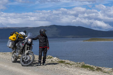 Frau neben ihrem geländegängigen Tourenmotorrad in Argentinien - CAVF86138