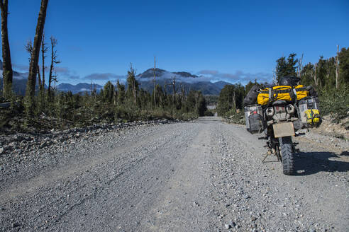 Auf der Carretera Austral auf einer Schotterstraße geparktes Tourenmotorrad - CAVF86162