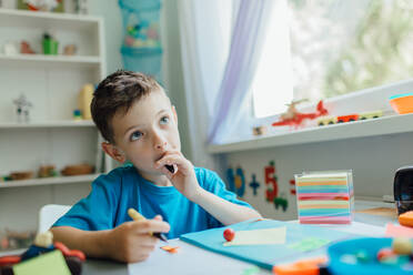 Thoughtful Boy Sitting At Table - EYF08271