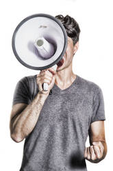 Mid Adult Man Screaming Over Megaphone While Standing Against White Background - EYF08276