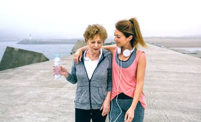 Mother And Daughter Walking At Beach - EYF08296