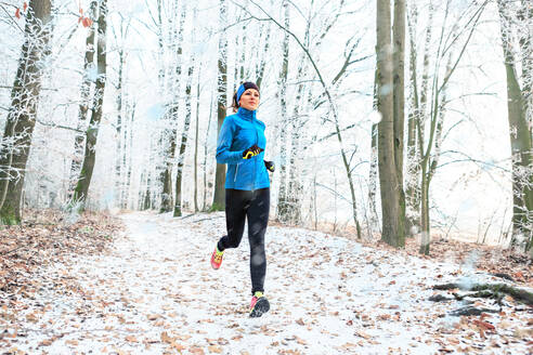 Volle Länge der Frau Joggen im Wald im Winter - EYF08321