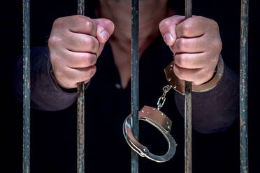 Mittelteil eines Gefangenen, der hinter Gittern steht - EYF08366