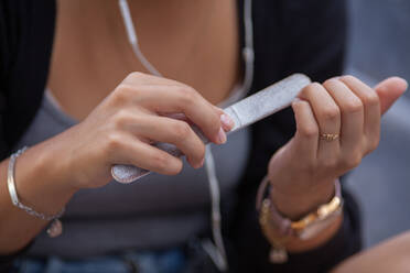 Midsection Of Woman Filing Nails - EYF08383