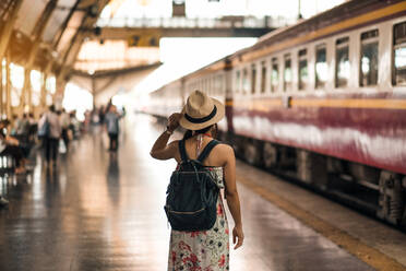 Rear View Of Mid Adult Woman With Backpack Standing At Railroad Station - EYF08388