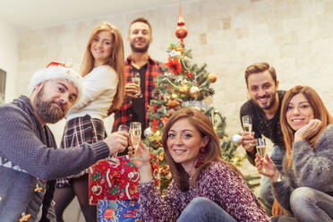 Porträt der fröhlichen Familie am Weihnachtsbaum zu Hause - EYF08441