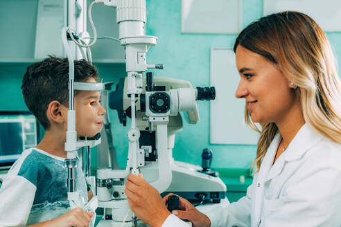 Smiling Ophthalmologist Doing Eye Test Of Boy - EYF08450
