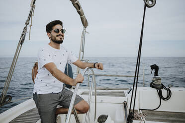 Happy man wearing sunglasses on a boat trip on a lake stock photo