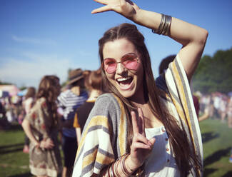 Porträt einer fröhlichen jungen Frau, die auf einer Party tanzt, während eines sonnigen Tages - EYF08628