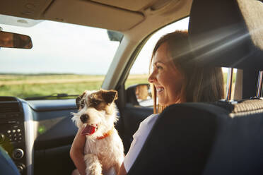 Smiling Woman With Dog Sitting In Car - EYF08647