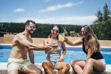 Freunde stoßen auf einer Poolparty mit Bier an - OCMF01372