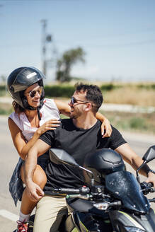 Pärchen auf Motorrad sitzend - OCMF01385