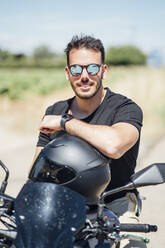 Biker with sunglasses sitting on motorbike - OCMF01387