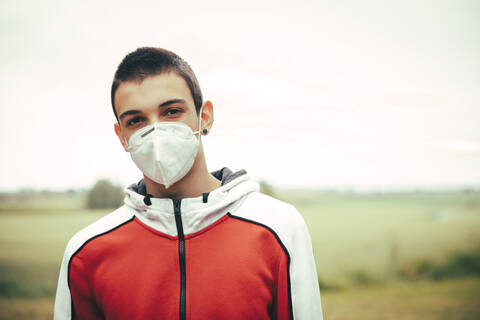 Portrait of teenager wearing protective mask outdoors stock photo