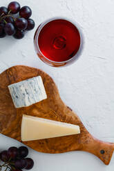 Nahaufnahme von Käse auf Schneidebrett mit Wein - EYF08666