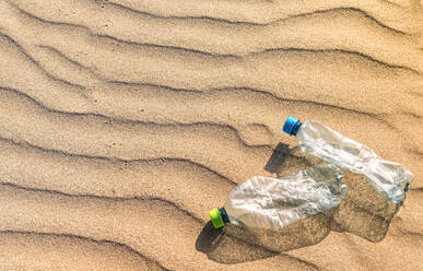 Plastikflaschen auf gewelltem Strandsand liegend - EHF00372