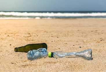 Im Strandsand liegende Glas- und Plastikflaschen - EHF00374