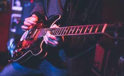 Mittelteil eines Mannes, der während eines Konzerts Gitarre spielt - EYF08823