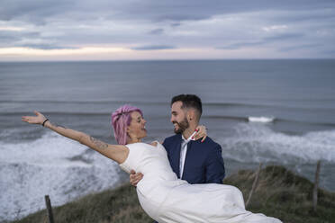 Bridal couple on viewpoint and ocean in the background - SNF00406