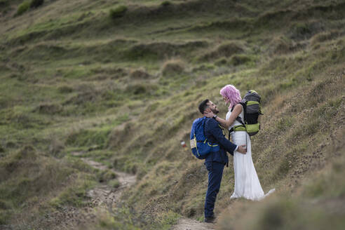 Brautpaar mit Kletterrucksäcken auf einem Wanderweg, Berg Urkiola, Spanien - SNF00415