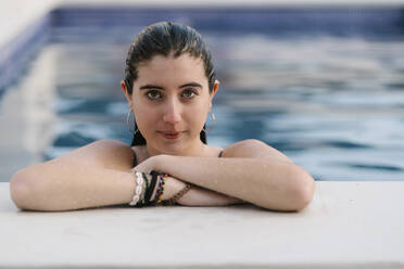 Porträt eines nassen Teenagers, der sich am Pool anlehnt - EGAF00316