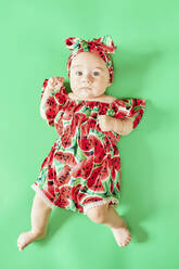 Porträt eines kleinen Mädchens im Sommerkleid auf grünem Hintergrund - KIJF03115