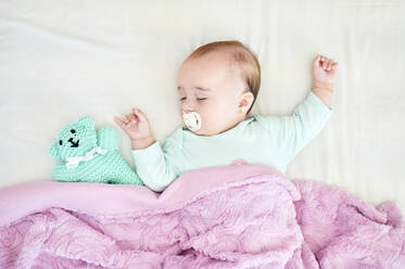 Portrait of sleeping baby girl with pacifier and cuddly toy - KIJF03120