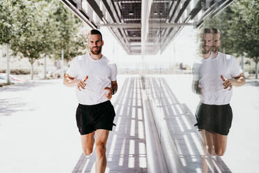 Man running along a building - EBBF00244