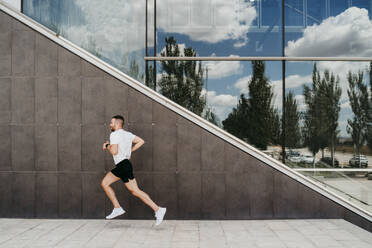 Man running along a building - EBBF00249