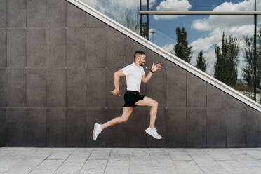 Man running along a building - EBBF00250