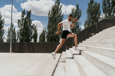 Male athlete running up stairs - EBBF00251