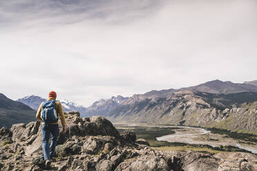 Mann mit Rucksack wandert auf Felsen gegen den Himmel, Patagonien, Argentinien - UUF20682