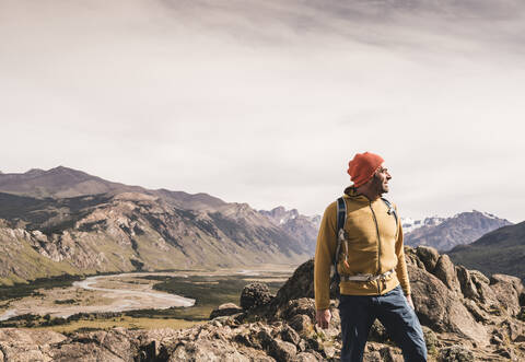 Männlicher Wanderer, der wegschaut, während er gegen Berge in Patagonien, Argentinien, steht, lizenzfreies Stockfoto